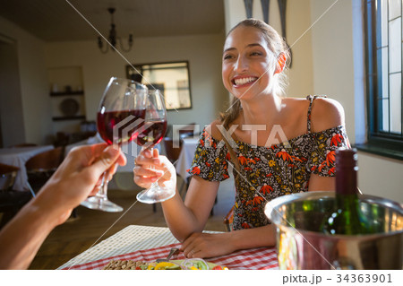 Happy woman toasting red wine with friend 34363901