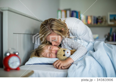 Mother kissing her daughter in the bedroom Mother kissing her daughter in the bedroom 34363906