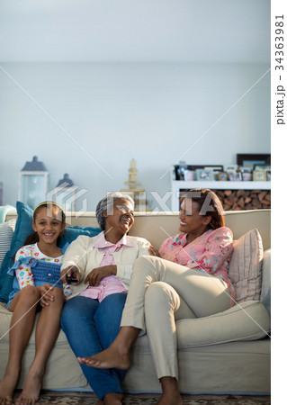 Smiling family watching television together in living room 34363981