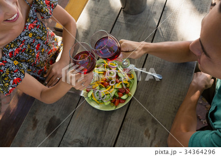 High angle view of friends toasting wineglasses 34364296