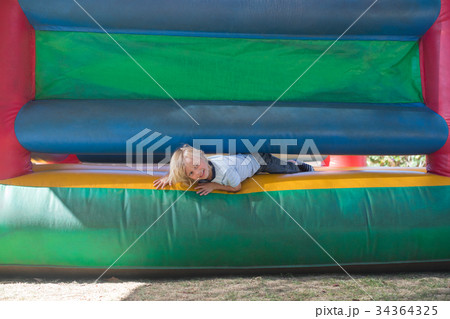 Portrait of happy boy playing on bouncy castle Portrait of happy boy playing on bouncy castle 34364325