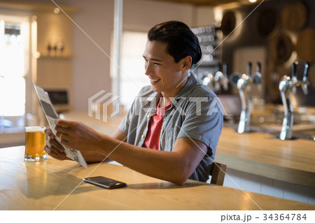 Man reading newspaper in a restaurant 34364784