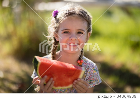 Cute girl having a watermelon slice in park 34364839