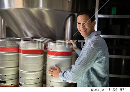 Manager checking beer keg in warehouse 34364974