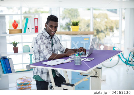 Executive working on laptop in office Executive working on laptop in office 34365136