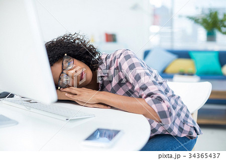 Female executive sleeping at desk 34365437