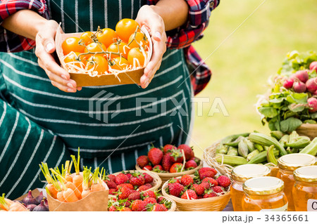 Midsection of woman holding tomatoes in box 34365661