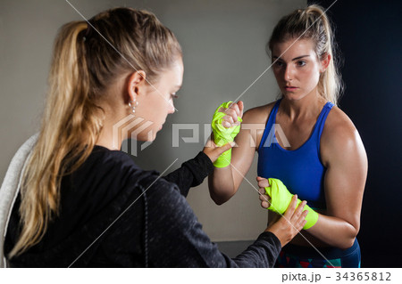 Trainer assisting woman in boxing Trainer assisting woman in boxing 34365812