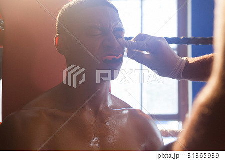 Trainer applying cream on man face 34365939