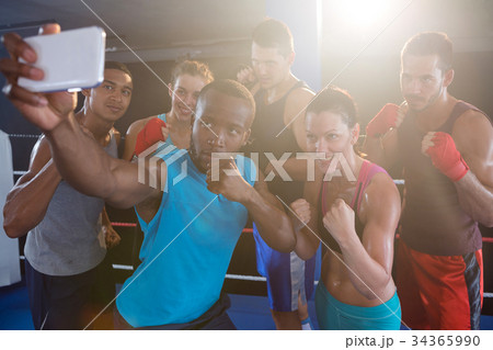 Young boxers taking selfie in fighting stance Young boxers taking selfie in fighting stance 34365990