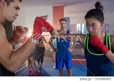 Young female boxer practicing with male Young female boxer practicing with male 34366065