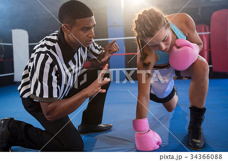 Referee gesturing to female boxer in ring Referee gesturing to female boxer in ring 34366088