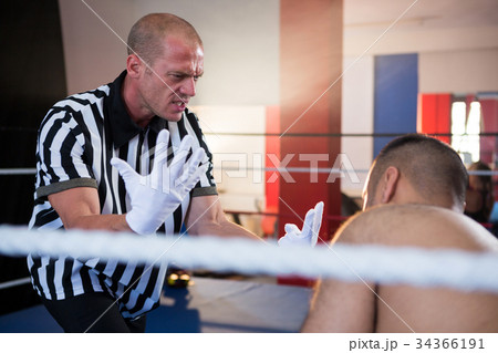 Referee gesturing to male boxer in ring Referee gesturing to male boxer in ring 34366191