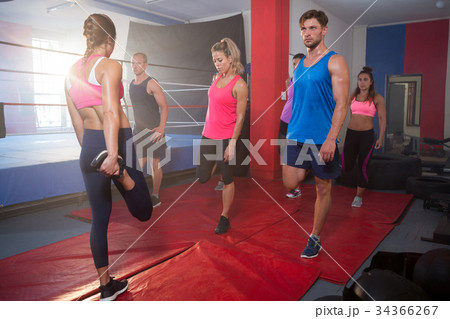 Young athletes stretching legs on exercise mats 34366267