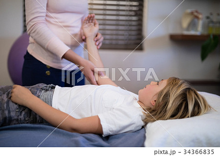 Midsection of female therapist examining arm with boy lying on bed Midsection of female therapist examining arm with boy lying on bed 34366835