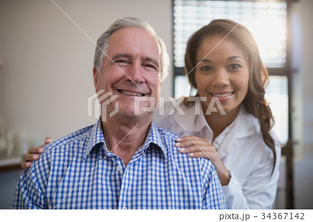 Portrait of smiling female therapist and senior male patient 34367142