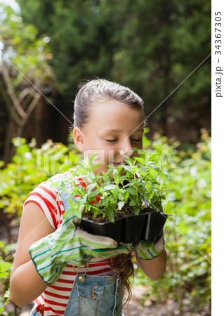 Girl smelling plants with eyes closed 34367305