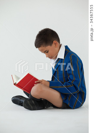 Schoolboy reading book on white background Schoolboy reading book on white background 34367555