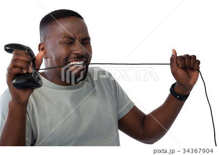 Frustrated man biting a wire of joystick 34367904