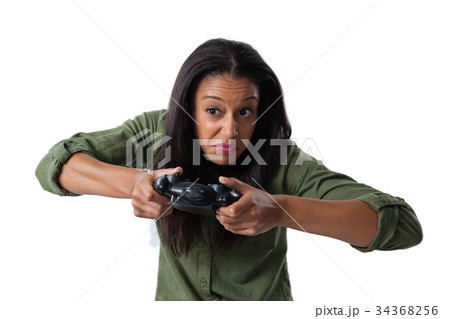 Woman making funny faces while playing video games Woman making funny faces while playing video games 34368256