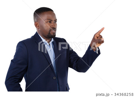Businessman pressing an invisible virtual screen Businessman pressing an invisible virtual screen 34368258