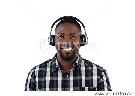 Man listening to music on headphones against white background Man listening to music on headphones against white background 34368376