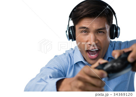 Young businessman making face while playing video game Young businessman making face while playing video game 34369120