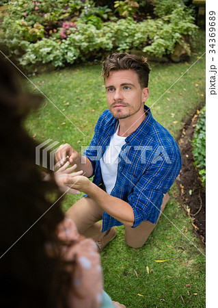 Handsome man wearing engagement ring to woman Handsome man wearing engagement ring to woman 34369689