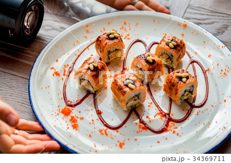 Food photographer takes picure of sushi rolls 34369711