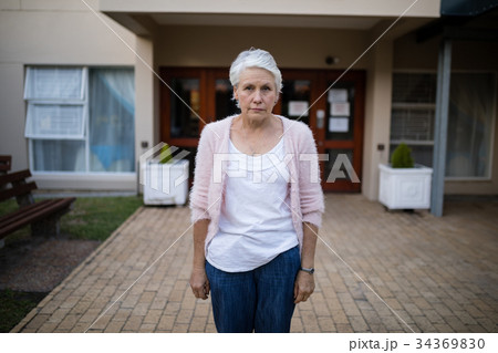 Portrait of serious senior woman standing on entrance 34369830