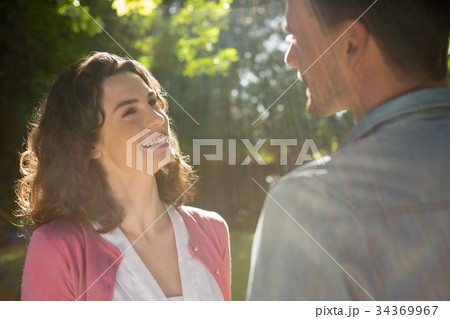 Romantic couple looking face to face in garden Romantic couple looking face to face in garden 34369967