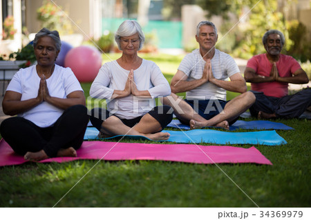 Senior people sitting in prayer position at park 34369979