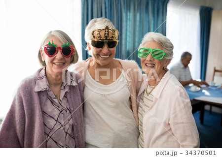 Smiling senior women wearing novelty glasses 34370501