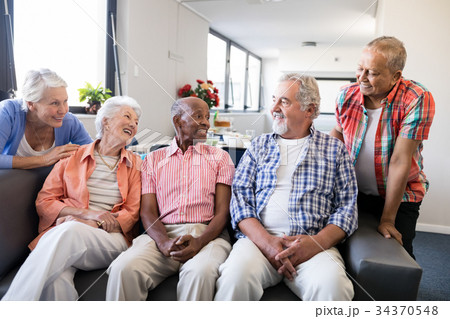 Smiling senior friends listening to man 34370548