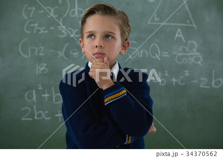 Schoolboy standing against chalkboard Schoolboy standing against chalkboard 34370562