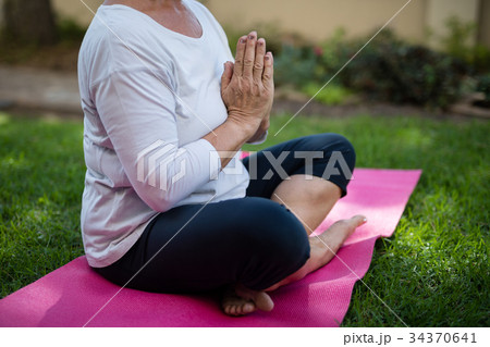 Low section of senior woman meditating in prayer position 34370641