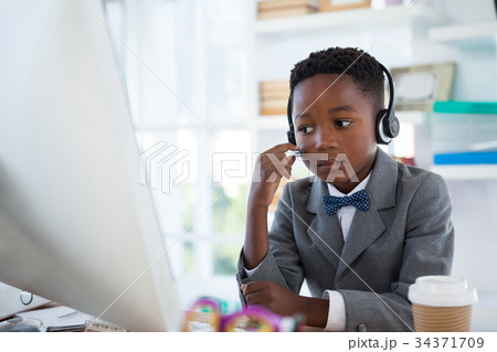 Businessman wearing headphone while working Businessman wearing headphone while working 34371709
