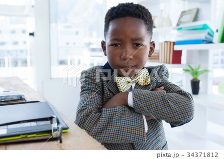 Portrait of businessman with arms crossed in office Portrait of businessman with arms crossed in office 34371812
