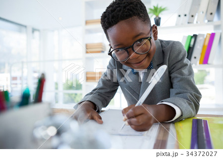 Portrait of businessman writing on paper 34372027