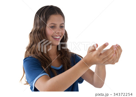 Smiling girl with hand cupped against white background 34372254