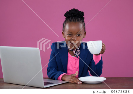 Portrait of businesswoman having coffee while making face 34372388