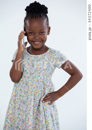 Portrait of smiling businesswoman with hand on hip talking on mobile phone 34372400