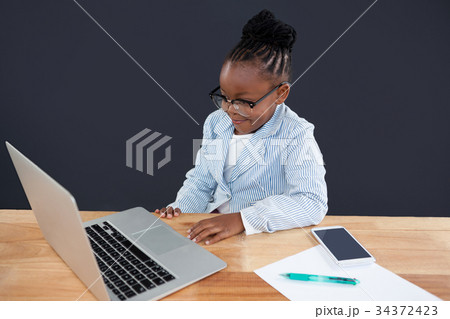 Smiling businesswoman wearing eyeglasses looking laptop Smiling businesswoman wearing eyeglasses looking laptop 34372423