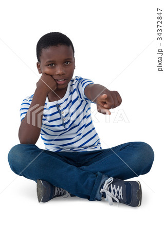 Sad boy pointing his finger against white background Sad boy pointing his finger against white background 34372847