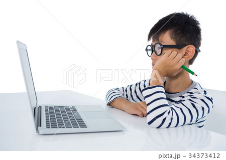 Boy sitting with laptop against white background 34373412