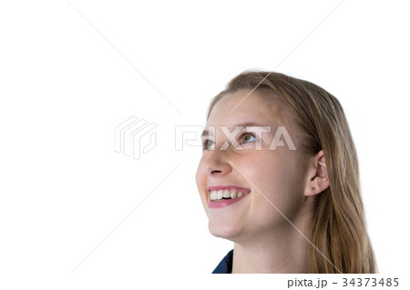 Thoughtful teenage girl smiling against white background Thoughtful teenage girl smiling against white background 34373485