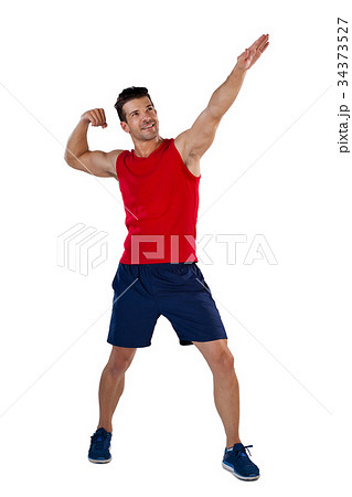 Full length of sports player flexing muscles with hand raised 34373527