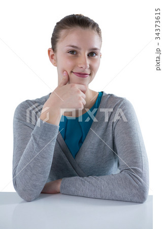 Smiling teenage girl sitting against white background Smiling teenage girl sitting against white background 34373615