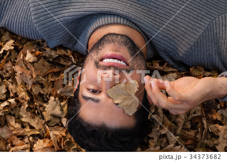 Overhead of man lying on autumn leaves 34373682