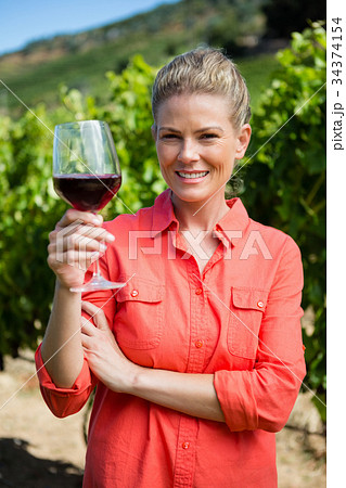 Portrait of female vintner holding glass of wine 34374154